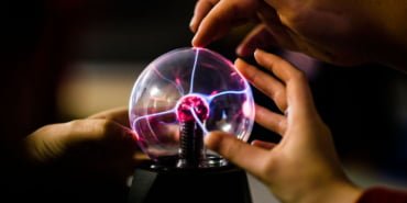 Pupils touching a plasma ball learning the principles of science physics in a secondary comprehensive school in Wales UK