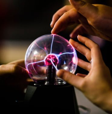 Pupils touching a plasma ball learning the principles of science physics in a secondary comprehensive school in Wales UK