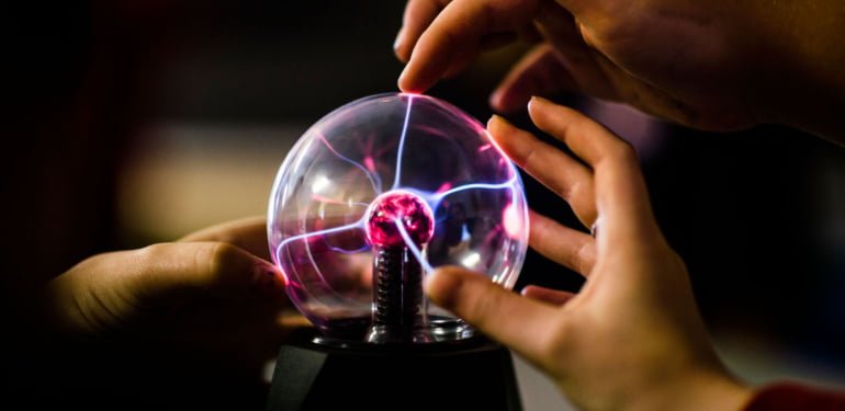 Pupils touching a plasma ball learning the principles of science physics in a secondary comprehensive school in Wales UK