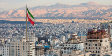 Waving,Iran,Flag,Above,Skyline,Of,Tehran,At,Sunset.
