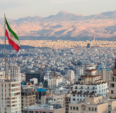 Waving,Iran,Flag,Above,Skyline,Of,Tehran,At,Sunset.