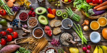 Vegan food backgrounds: large group of fruits, vegetables, cereals and spices shot from above